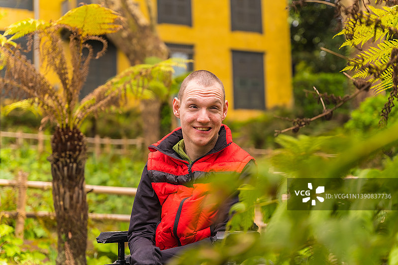 城市公园里坐轮椅微笑的年轻男人肖像图片素材