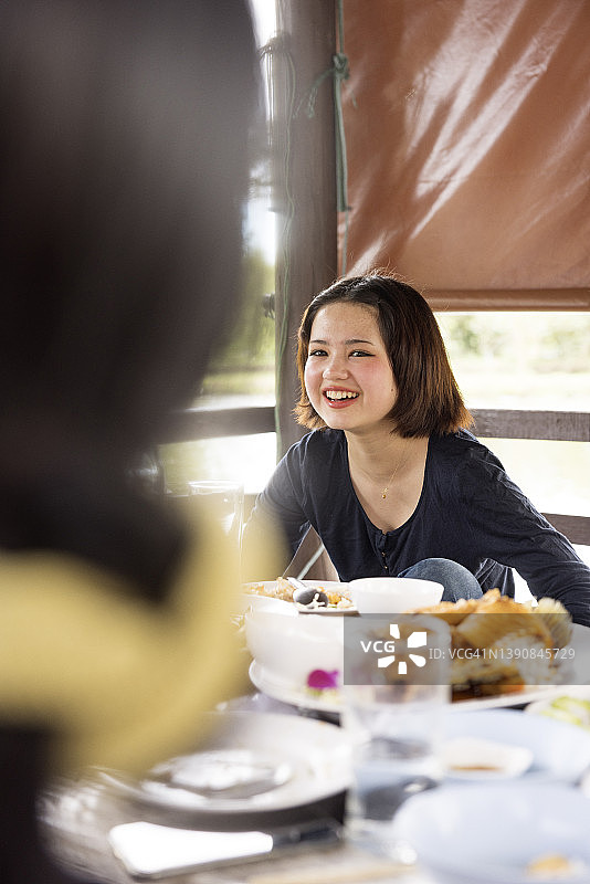 在户外餐桌旁微笑的少女图片素材