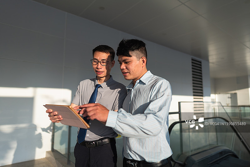 销售代表手持平板电脑与客户沟通图片素材