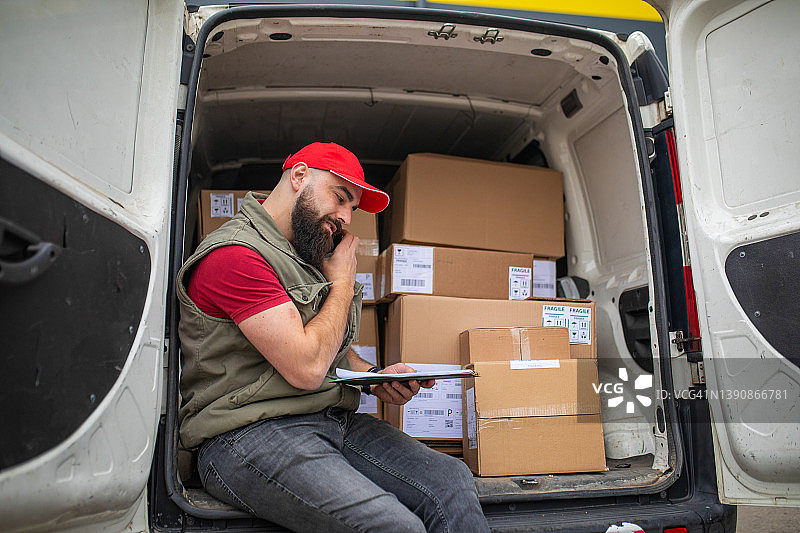 送货员在送货前与下一位客户通电话图片素材