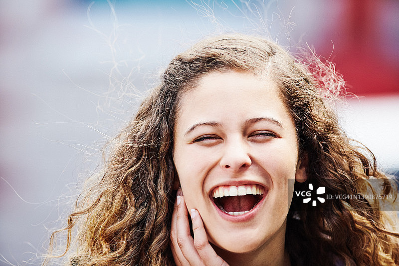 户外开怀大笑的漂亮年轻卷发女人图片素材