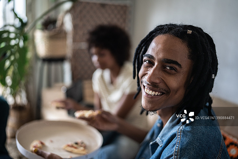 在家和女朋友一起吃披萨的年轻男人照片图片素材