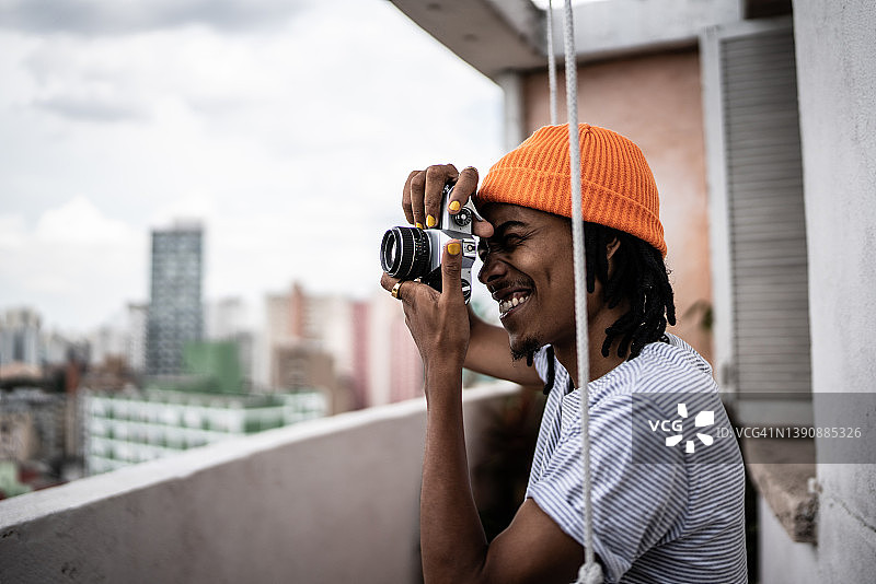 年轻男人在公寓门廊拍照图片素材