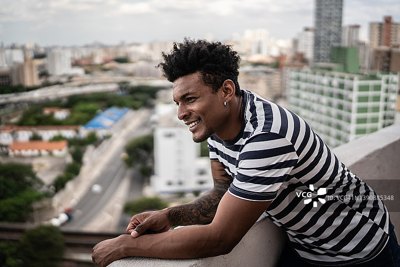 男人在公寓的门廊里看着远方沉思图片素材