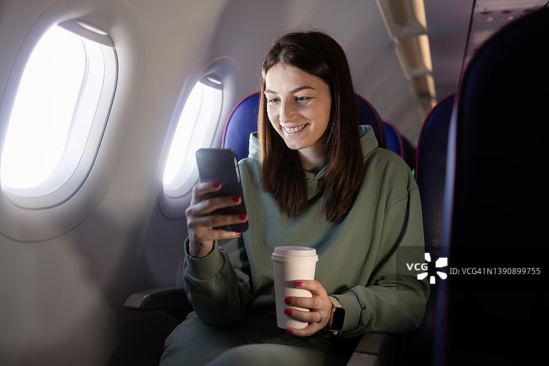 女孩在飞机上使用智能手机图片素材