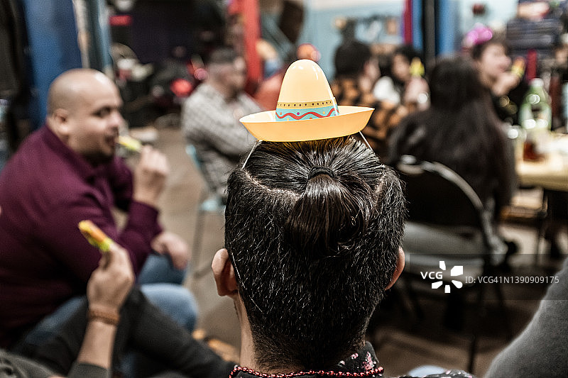 在节日派对上戴着派对帽的拉丁裔男人图片素材