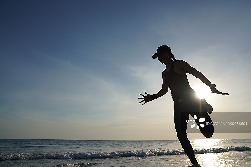 在海滩上跑步的运动女性剪影图片素材