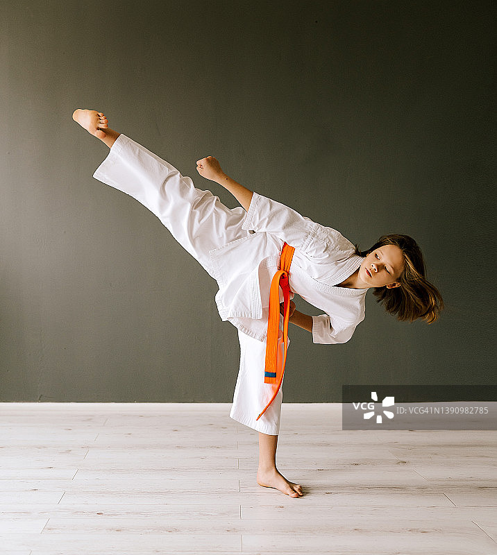10岁女孩进行空手道训练，练习回旋踢图片素材