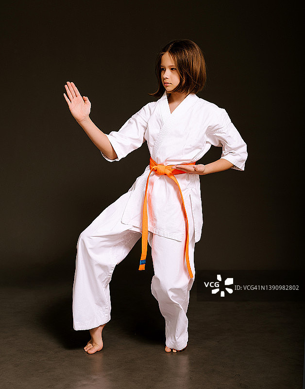 10岁女孩进行空手道训练，练习回旋踢图片素材