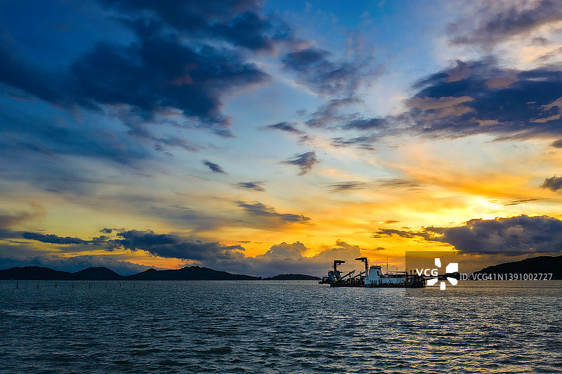 黄昏时分的采砂船与壮丽的天空航拍视角图片素材