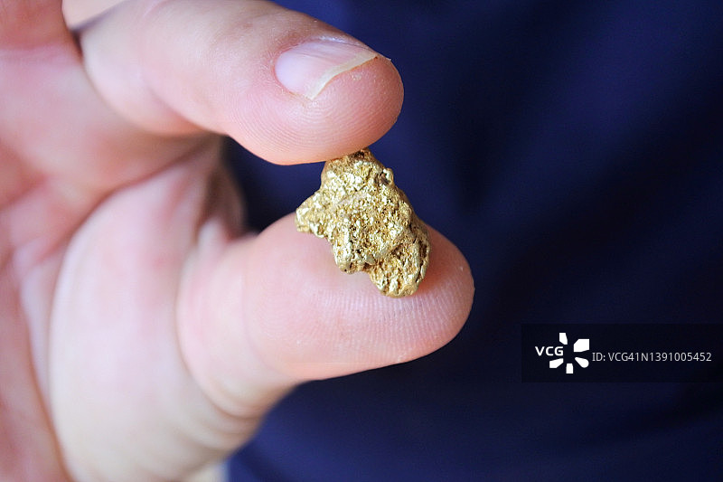 手持大块金块的人图片素材