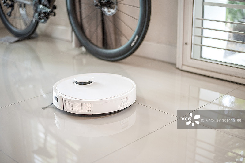 白色自动真空吸尘器清洁地板图片素材