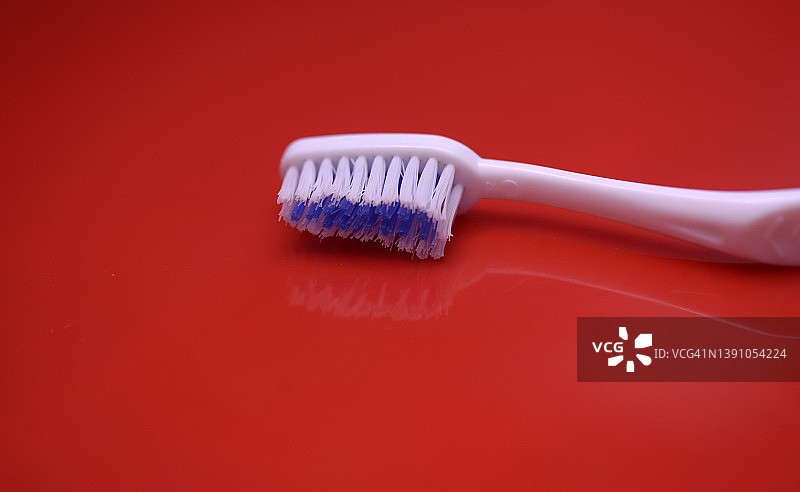 红色背景上的白色牙刷图片素材