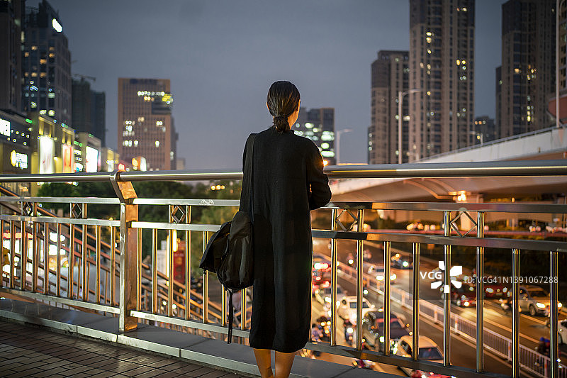 夜晚街头的年轻亚洲女人背影图片素材