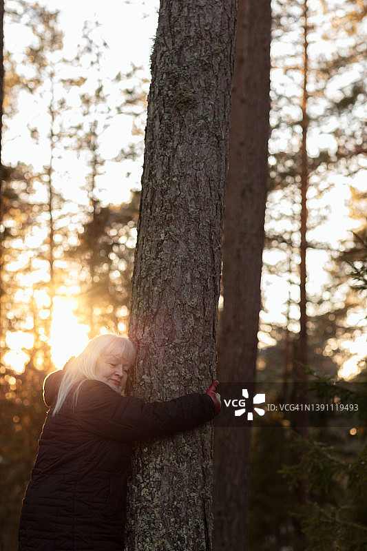 美丽的年老妇女放松在自然在日落图片素材