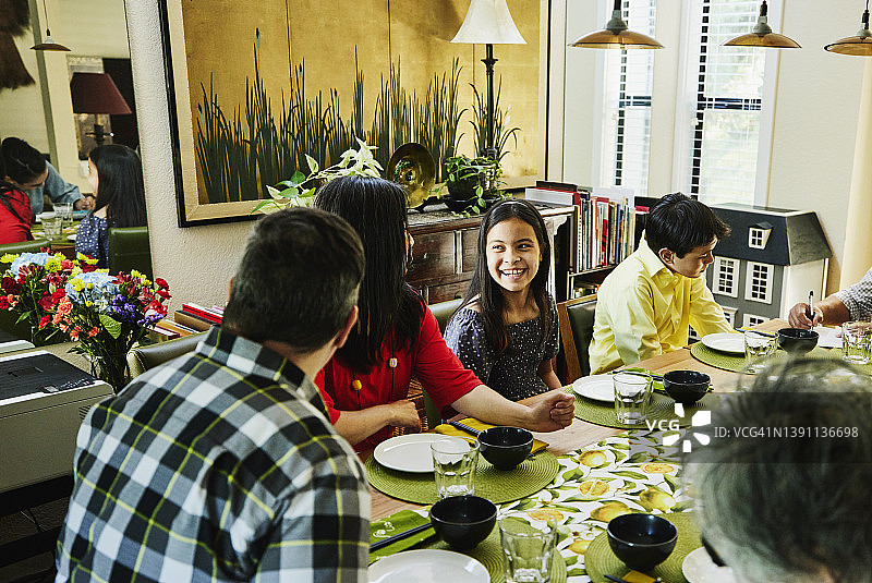 笑容满面的多代同堂家庭在晚餐前坐在饭桌旁图片素材