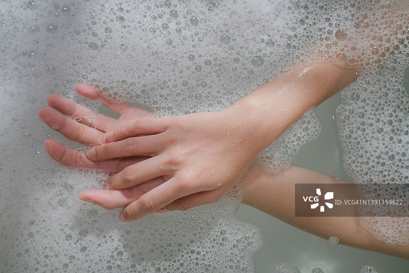 女人在浴缸里起泡泡的特写图片素材