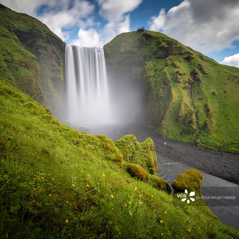 夏季蓝天下冰岛的斯科加瀑布，是冰岛中南部地区的热门旅游景点图片素材