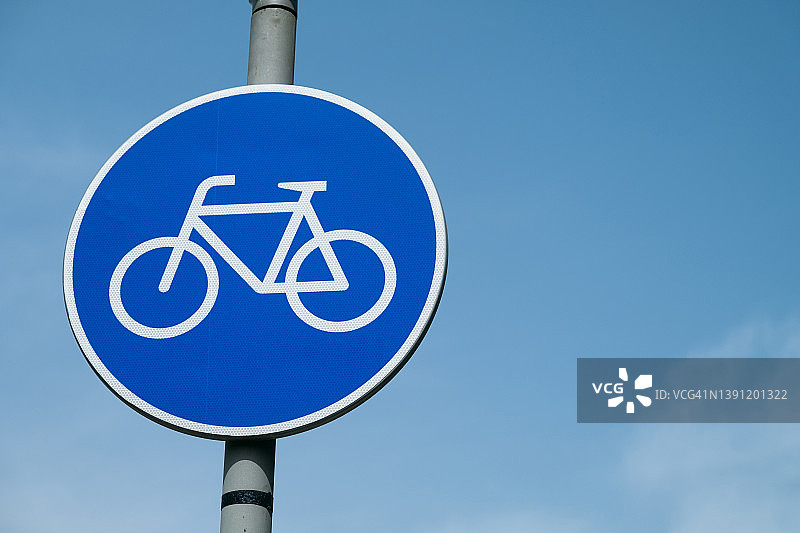 蓝天下的自行车道标志。警告路标。安全概念，遵守交通规则。图片素材