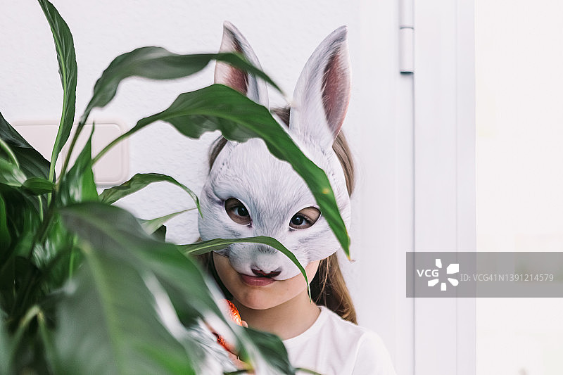 戴兔子面具和拿巧克力蛋庆祝复活节的女孩图片素材