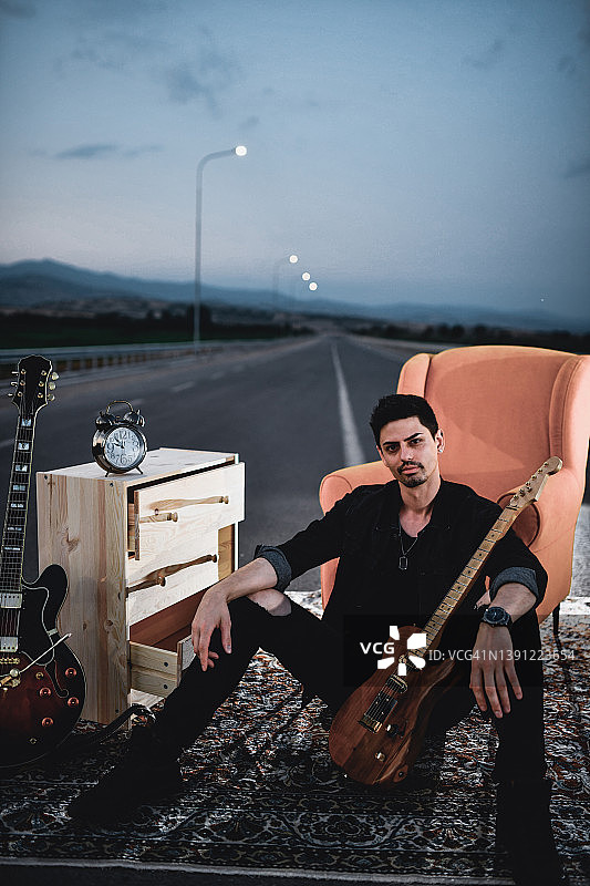 现代音乐家在公路中央设置高速公路、橱柜、椅子和吉他的时间流逝图片素材