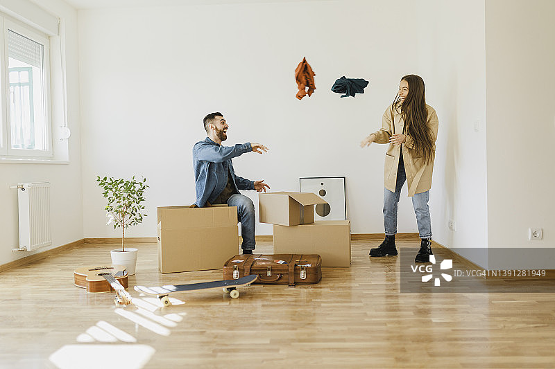 在他们的新公寓里打开物品的微笑情侣图片素材