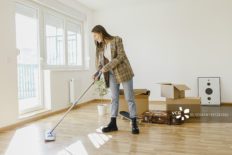 年轻女人打扫并准备搬入新家图片素材