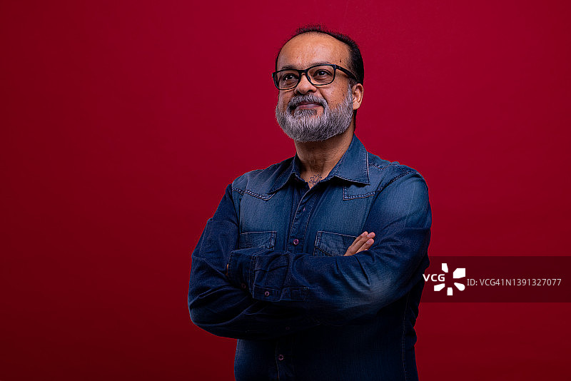 红色背景下留着胡须的年轻中东男子图片素材