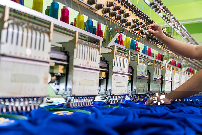 工人在纺织厂的刺绣区使用缝纫机工作图片素材