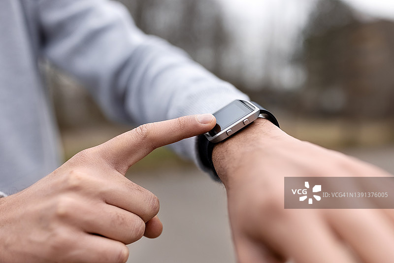 在智能手表上监测健身过程的男人特写图片素材