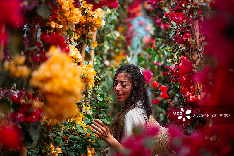 在植物苗圃中身穿九重葛服饰的美丽女人图片素材