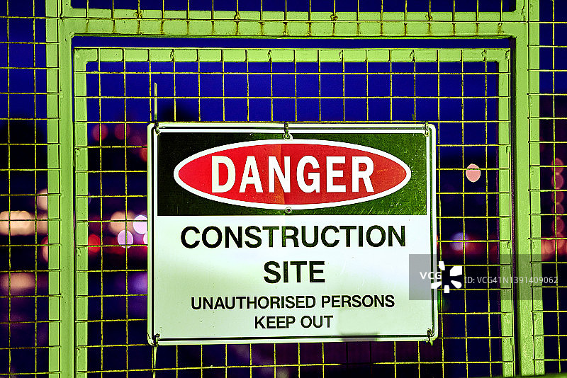 夜间带有危险施工现场标志的金属安全门图片素材