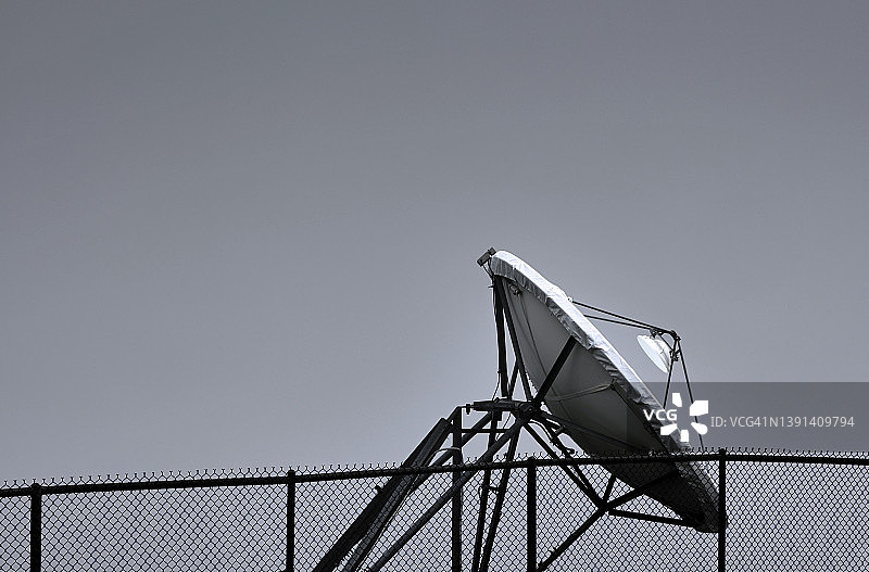 卫星天线和安全围栏，灰色背景图片素材
