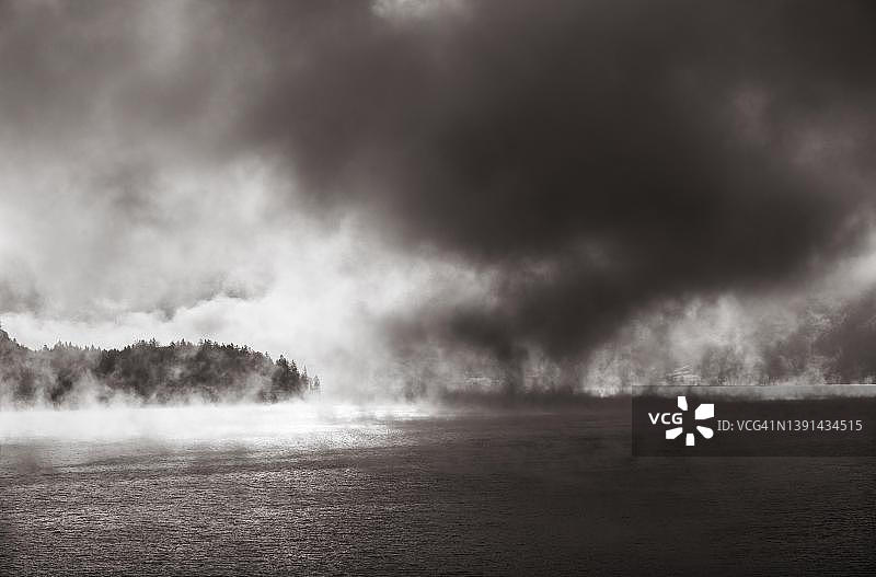 奥地利沃尔夫冈湖晨雾中的阳光，棕褐色调，秋季氛围图片素材