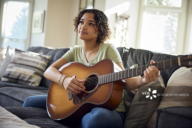 少女在沙发上弹吉他图片素材