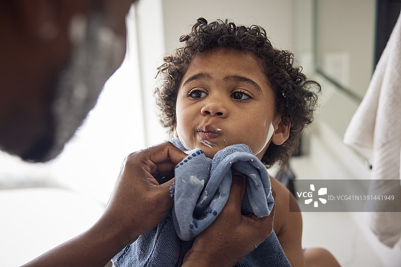 非裔美国父亲在浴室用毛巾给儿子擦干身体图片素材