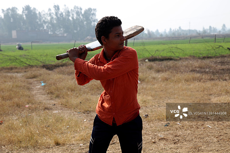 在村庄里打板球的乡村男孩图片素材