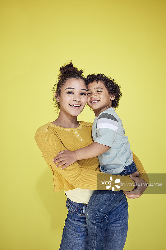 黄底背景上的姐姐和弟弟图片素材