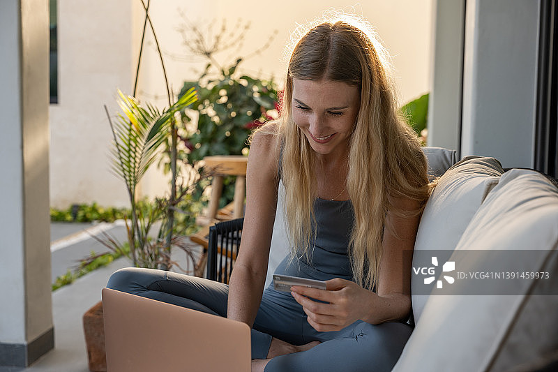 年轻女人用信用卡在电脑上进行网购图片素材