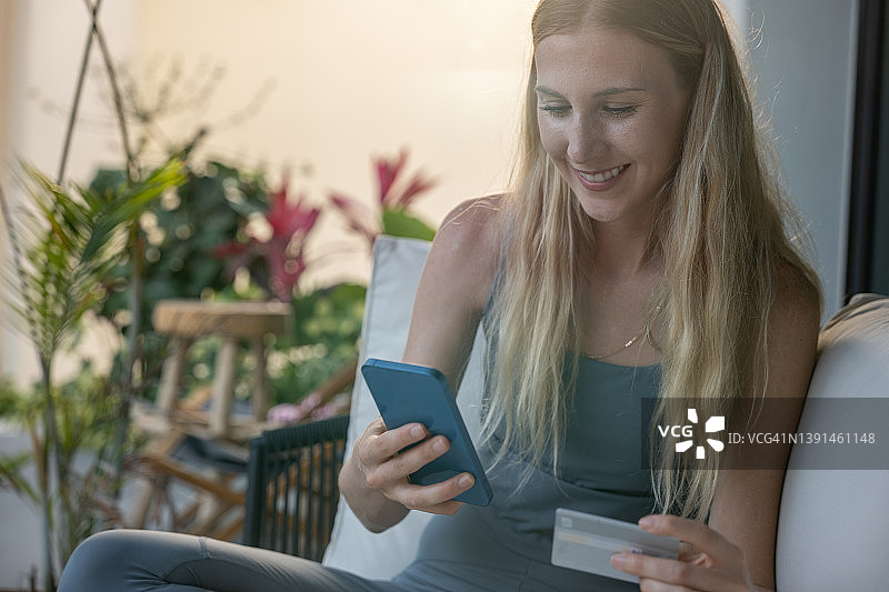 年轻女人用信用卡进行手机支付图片素材