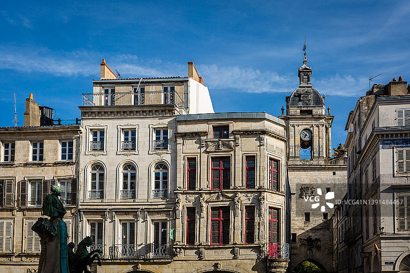 法国拉罗谢尔老城区的“教堂街广场”及背景中的大钟图片素材