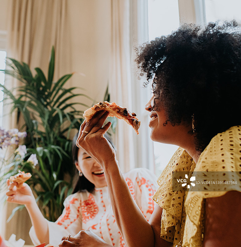 一位女士和朋友一起享用披萨图片素材