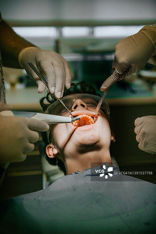 牙科保健员为患者清洁牙齿，牙医和患者图片素材