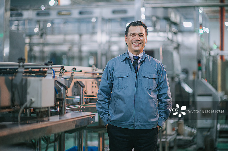 微笑看着镜头的马来西亚裔成熟工厂经理图片素材