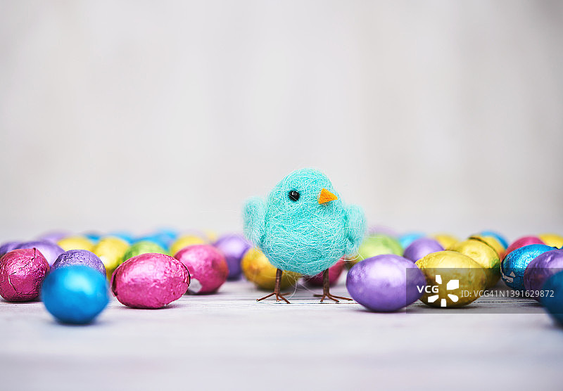 现代复活节背景与可爱的复活节小鸡被箔覆盖的巧克力复活节彩蛋包围图片素材