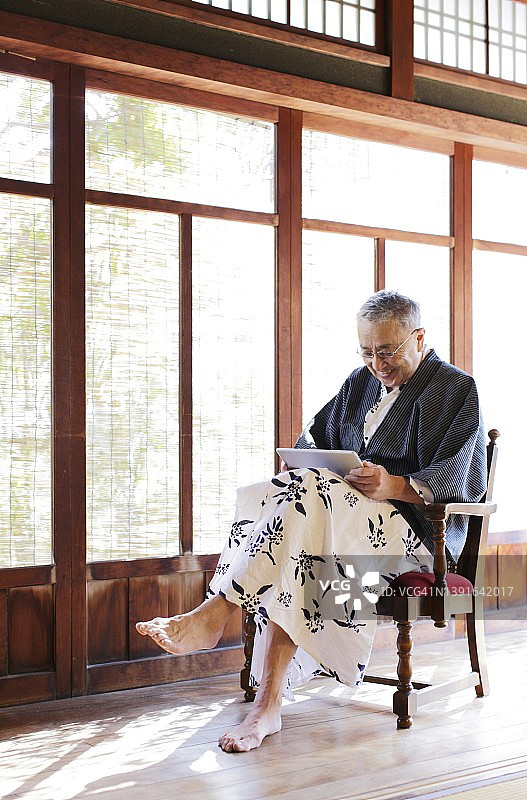 穿日式浴衣使用平板电脑的年长男性图片素材