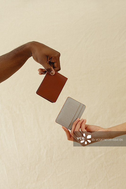 一男一女的手拿着两种不同的钱包图片素材