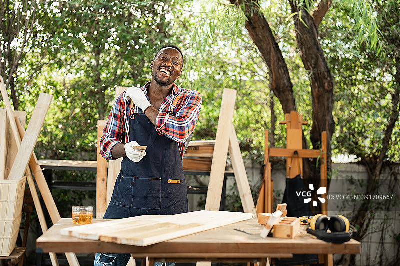 快乐的木匠 мужчина 在木材上油漆时跳舞图片素材