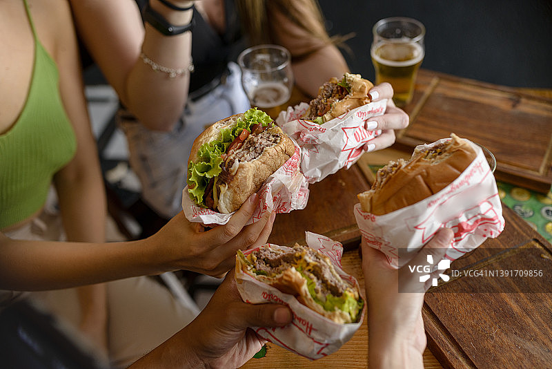 酒吧里年轻人手中的零食细节图片素材