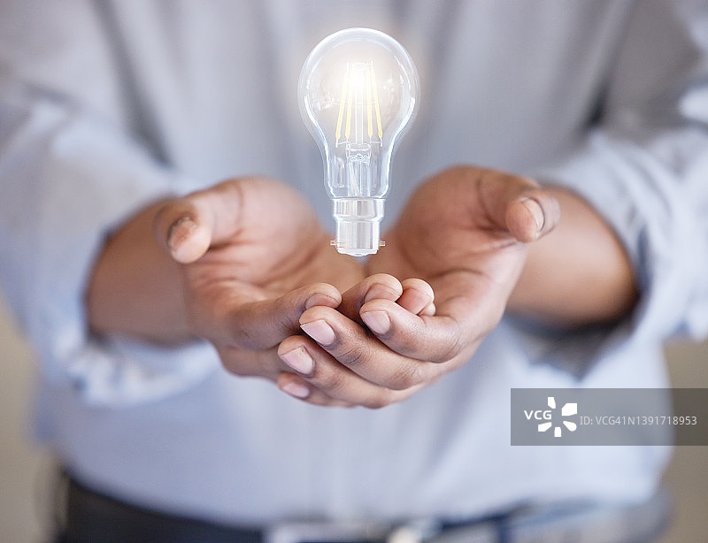 手持灯泡的身份不明的商人特写镜头图片素材